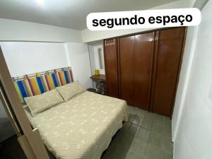a small bedroom with a bed and a wooden cabinet at Praia de Ponta Verde com lavadora, wi-fi, garagem - quarto andar in Maceió +46 photos