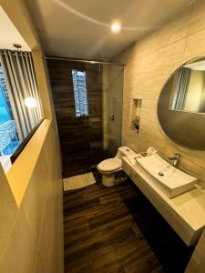 a bathroom with a sink and a toilet and a mirror at Hotel Campo & Leña in Cieneguilla