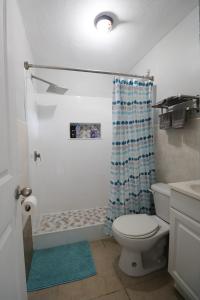 łazienka z toaletą i zasłoną prysznicową w obiekcie Dolphin Villas AXA w mieście Crocus Hill