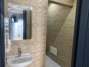 La salle de bains est pourvue d'un lavabo et d'un miroir. dans l'établissement Sunrise Center Bonapriso 111, à Douala