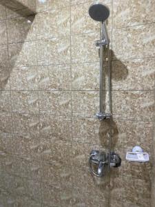 La salle de bains est pourvue d'une douche et d'une barre de métal. dans l'établissement Sunrise Center Bonapriso 111, à Douala