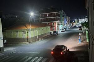 un coche aparcado en una calle de la ciudad por la noche en Mendes Homestay - B&B In The Heart Of Praia Ext en Praia