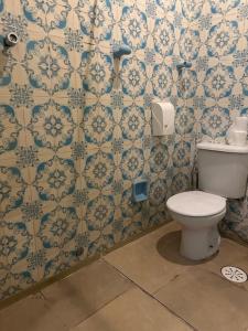 a bathroom with a toilet and blue and white wallpaper at Hotel Internacional São Paulo in Sao Paulo