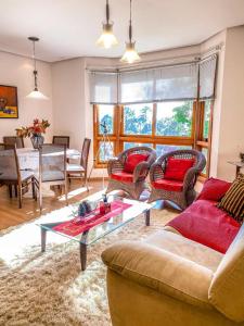 uma sala de estar com sofás e uma mesa em Apartamento Lago Negro em Gramado