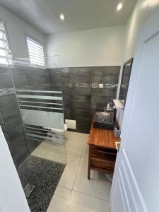 bagno con doccia e tavolo in legno di Entre forêt et mer a Gros-Morne
