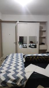 een slaapkamer met een bed en een grote spiegel bij King's Property in Jakarta