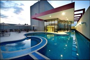 a large swimming pool in front of a building at Radisson Belém - Flat in Belém
