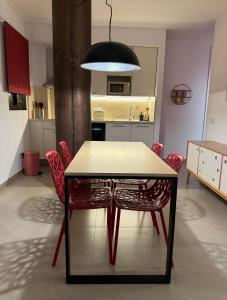 a dining room table with red chairs in a kitchen at Aparthotel Boutique Poniente Playa in San Antonio