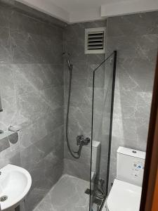 a bathroom with a shower and a toilet and a sink at Kemer Manastır Hotel in Kemer