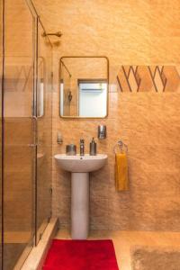 La salle de bains est pourvue d'un lavabo et d'une douche avec un miroir. dans l'établissement Stylish 2-bed Apartment Spintex, à Kwedonu