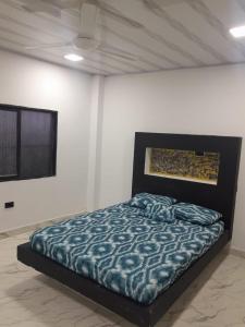 Schlafzimmer mit einem Bett mit blauer Decke in der Unterkunft CASA DEL ARBOL in Doradal