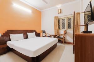 Habitación de hotel con cama y TV en OYO Hotel Bommana Residency en Rajahmundry