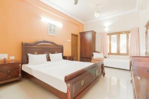 a bedroom with a large bed with white sheets at OYO Hotel Bommana Residency in Rājahmundry