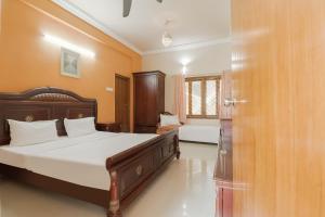 a bedroom with a large bed in a room at OYO Hotel Bommana Residency in Rājahmundry