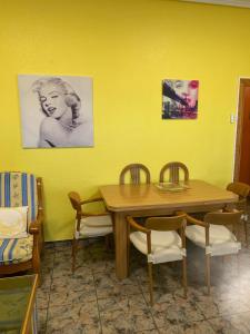 a dining room with a wooden table and chairs at Broadway es Mar in El Perelló +14 photos