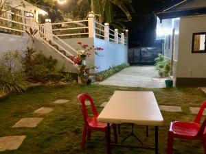 a table and two chairs in a yard at night at Altheos Place Romblon Cottage 1 in Romblon