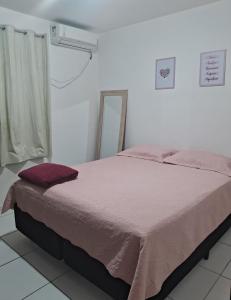 - une chambre avec un grand lit et une couverture rose dans l'établissement Apartamento aconchegante perto do shopping, à São Luís