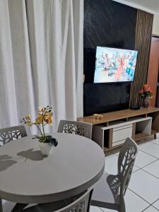 une salle à manger avec une table blanche et une télévision dans l'établissement Apartamento aconchegante perto do shopping, à São Luís