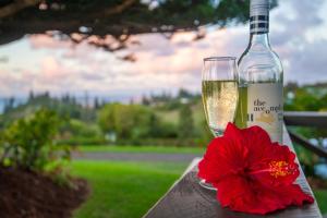 a bottle of champagne and a red flower on a table at Cascade Garden Apartments in Burnt Pine