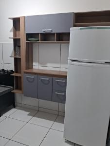Il comprend une cuisine équipée d'un réfrigérateur blanc et d'étagères en bois. dans l'établissement Apartamento aconchegante perto do shopping, à São Luís