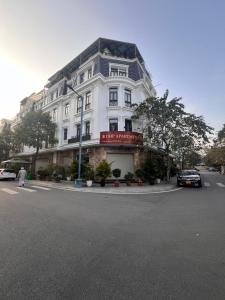 un edificio blanco en una calle con un coche aparcado delante en HPT Apartment chuỗi căn hộ Hoàng Huy Riverside HP, en Abbeyfeale