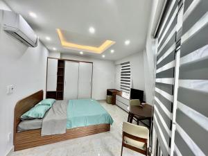 1 dormitorio con 1 cama, escritorio y silla en HPT Apartment chuỗi căn hộ Hoàng Huy Riverside HP, en Abbeyfeale