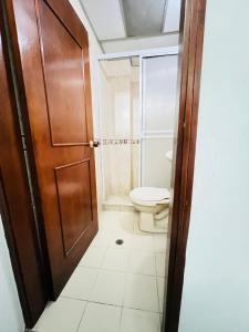 a bathroom with a toilet and a wooden door at Hotel Coco Beach Santa Marta in Santa Marta +16 photos