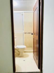 a bathroom with a toilet and a glass shower at Hotel Coco Beach Santa Marta in Santa Marta