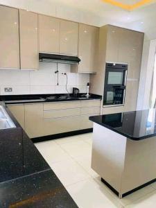 een keuken met witte kasten en een zwart aanrecht bij 2nd street home in Lusaka