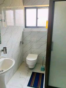 een witte badkamer met een toilet en een wastafel bij 2nd street home in Lusaka