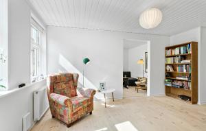 a living room with a chair and a table at Stunning Home In Rudkbing With Kitchen in Rudkøbing