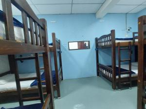 a room with three bunk beds and a blue wall at DZ Backpackers in Semporna +9 photos