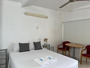 1 dormitorio con 1 cama blanca y 2 toallas en Shell Motel (Pearly Shell Motel), en Bowen