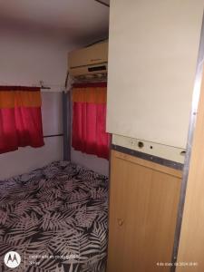 a small bedroom with a bed in a small room at Casa Rodante en granja in Santiago del Estero