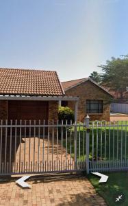 a white fence in front of a house at Centurion Family House in Centurion