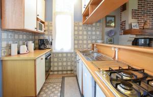a kitchen with a stove and a sink at Cozy Home In Saint-Pierre-En-Auge in Sainte-Marguerite-de-Viette