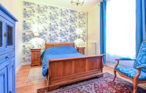 a bedroom with a bed and a blue and white wallpaper at Cozy Home In Saint-Pierre-En-Auge in Sainte-Marguerite-de-Viette +27 photos