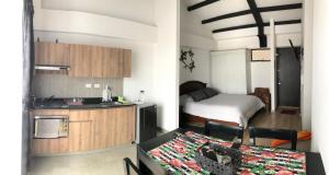 eine kleine Küche und ein Schlafzimmer mit einem Bett in der Unterkunft Apartamento en La Candelaria, centro histórico Bogotá in Bogotá