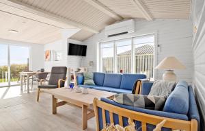 salon z niebieskimi kanapami i stołem w obiekcie 2 Bedroom Nice Home In Vordingborg w mieście Vordingborg