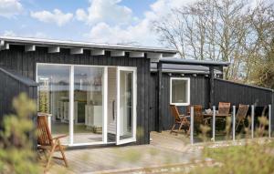 ein schwarzes Haus mit einer Terrasse und einem Tisch in der Unterkunft 2 Bedroom Nice Home In Vordingborg in Vordingborg