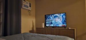 uma televisão de ecrã plano sentada numa cómoda num quarto em BRAND NEW SEMI-FURNISHED STUDIO @ AVIDA SPIRA CDO em Cagayan de Oro