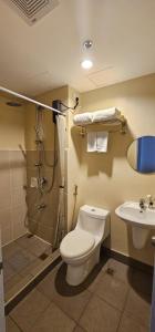 uma casa de banho com um WC, um chuveiro e um lavatório. em BRAND NEW SEMI-FURNISHED STUDIO @ AVIDA SPIRA CDO em Cagayan de Oro