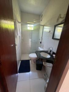 La petite salle de bains est pourvue d'un lavabo et de toilettes. dans l'établissement hospedagemsaopedro apartamento com garagem a 13 km de Cabo frio 22 km de arraial do cabo, à São Pedro da Aldeia