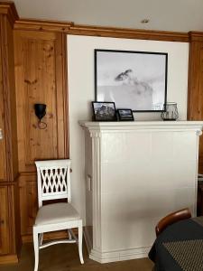 a white chair next to a white wall with a picture at Ferienhaus 4 Peaks in Bayerisch Gmain