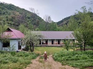a person walking down a dirt road in front of a house at CBT Arkit guest house in Arkit