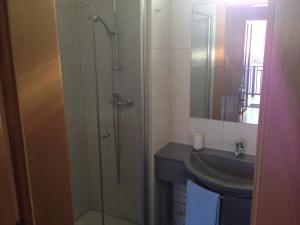 een badkamer met een glazen douche en een wastafel bij Winzerhof Klua Hoada in Illmitz