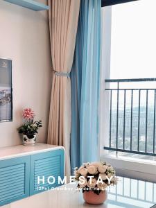 een kamer met een raam met blauwe gordijnen bij Homestay Hạ Long in Ha Long