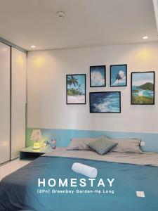 een slaapkamer met een bed en foto's aan de muur bij Homestay Hạ Long in Ha Long