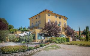 a yellow building with an umbrella in front of it at Hotel Il Roscio in Attigliano