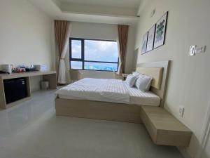 ein Schlafzimmer mit einem Bett und einem großen Fenster in der Unterkunft Island Sunset Hotel - Đảo Phú Quý in Cu Lao Thu